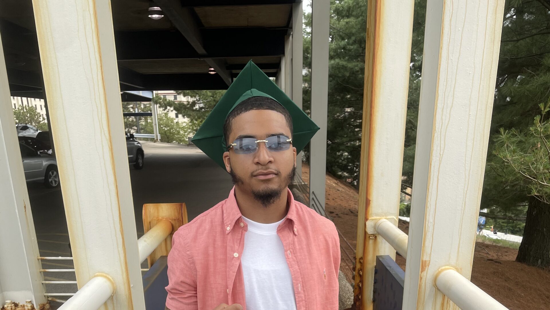 Kivon posing in his graduation cap with his diploma