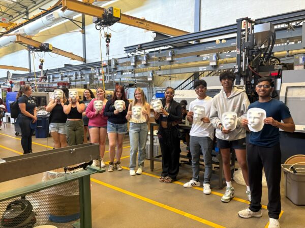 Students pose with their molded plastic projects in the Plastics Engineering Technology lab