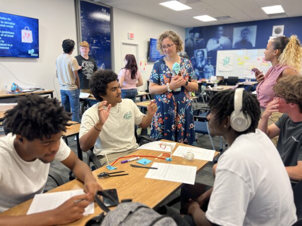 Students at table talking to instructor