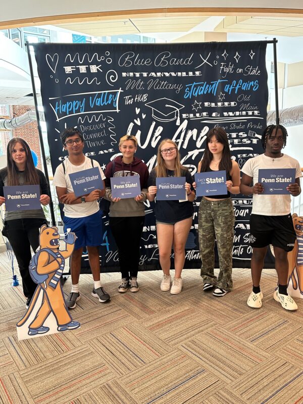 Learners stand in front of a We Are sign