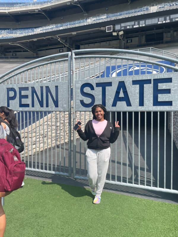 A learner poses at the gate of Beaver Stadium
