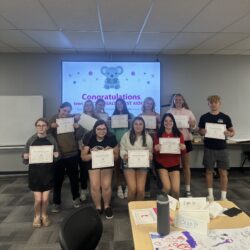 group of students posing and holding paper certificates for completing teen Mental Health First Aid training
