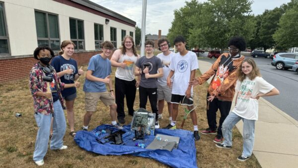 Student standing around smashed objects