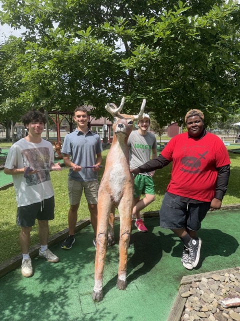 4 students posing on mini golf course
