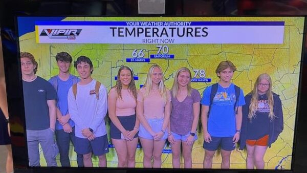 Summer Program learners stand in front of a green-screen weather map at WTAJ
