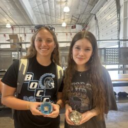 Two students posing with completed projects.