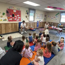A Summer Discovery student reads to a group of preschoolers