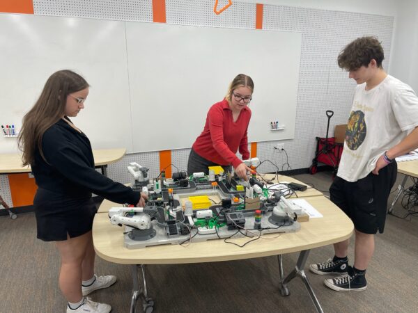 two students and intern at Digital Foundry looking at robot