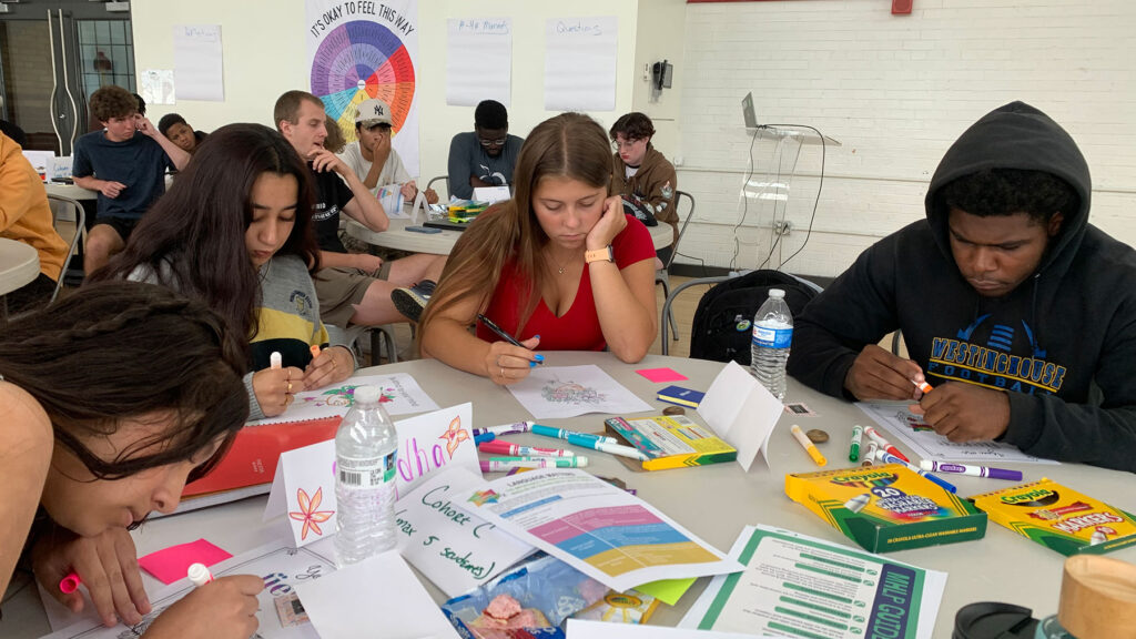 Learners work on a project with markers.