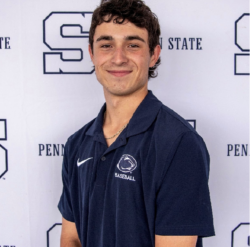 Keagan in blue Penn State polo in front of white Penn State logo backdrop