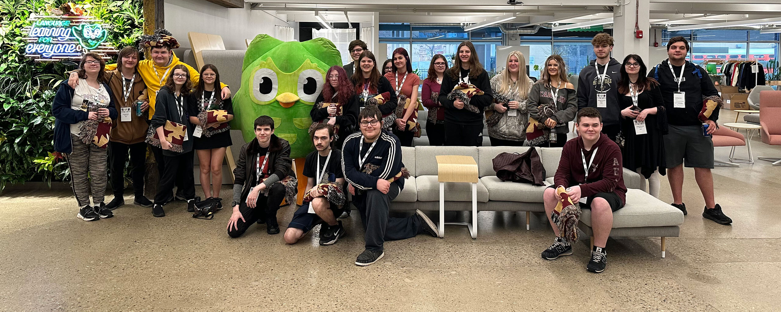 Group of students standing with the Duolingo mascot