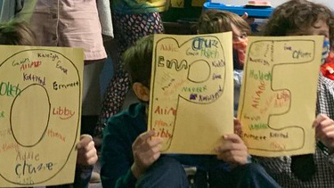 Elementary students holding signs with messages of hope