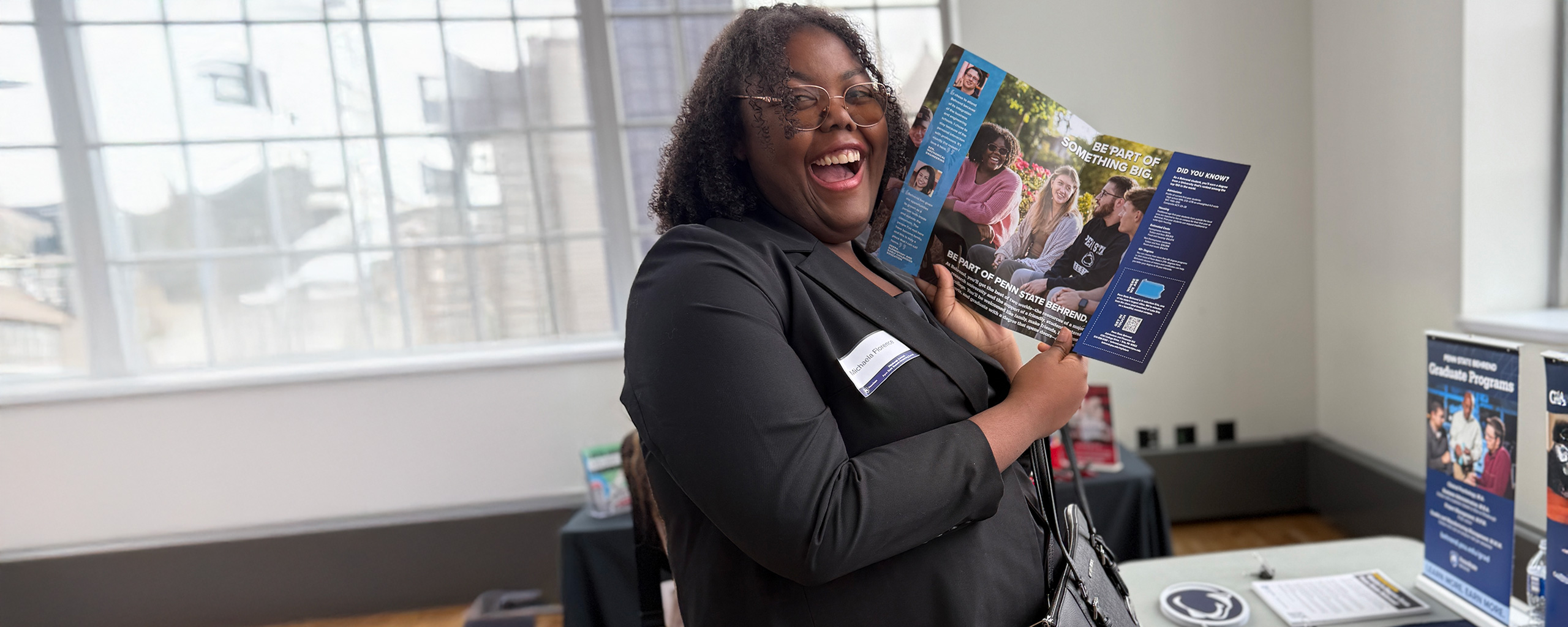 Young professional holding a brochure from the Readiness Institute at Penn State