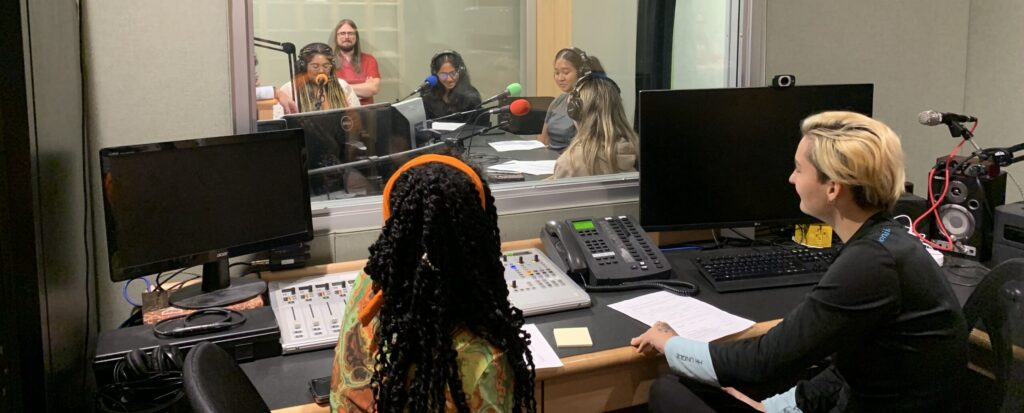 Students sitting in a podcast booth
