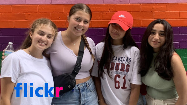 Four Summer Discovery students standing in front of a colorful wall